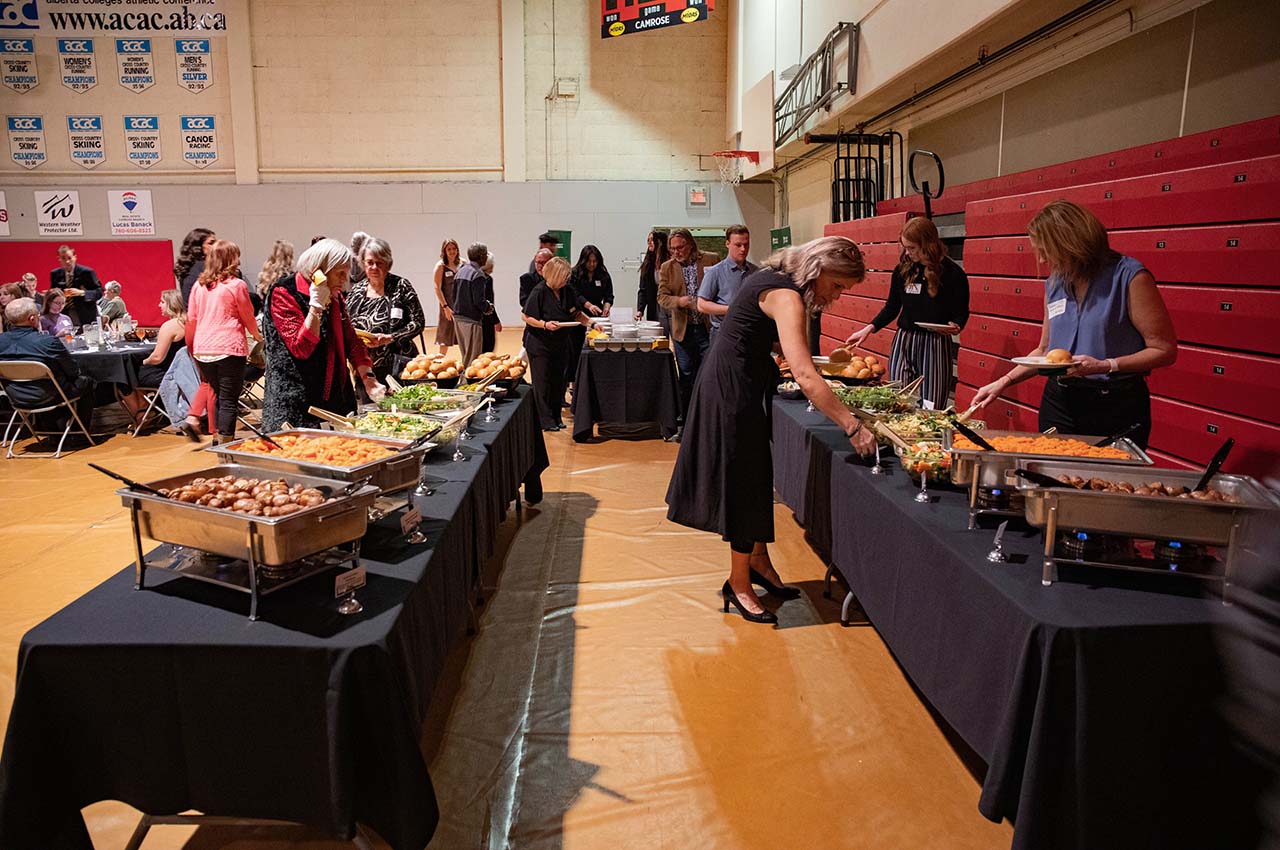 People dishing up at buffet tables.