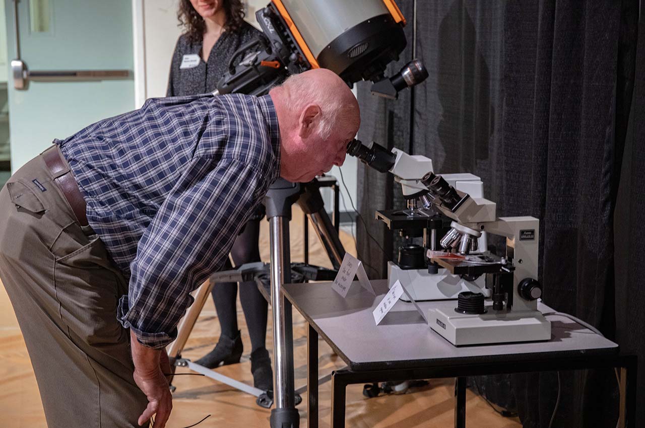 A man looking into a telescope.