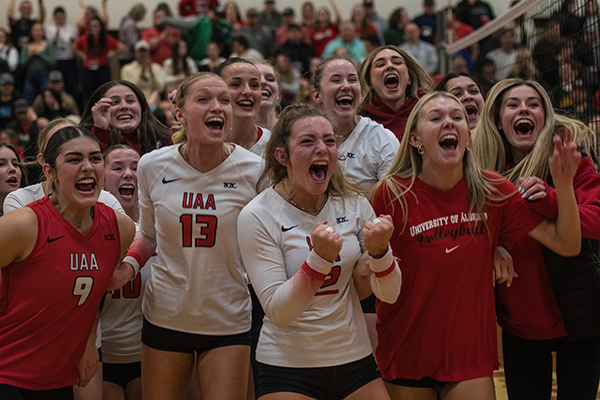 Members of the Vikings women's volleyball team celebrating on the court in the Augustana gymnasium.