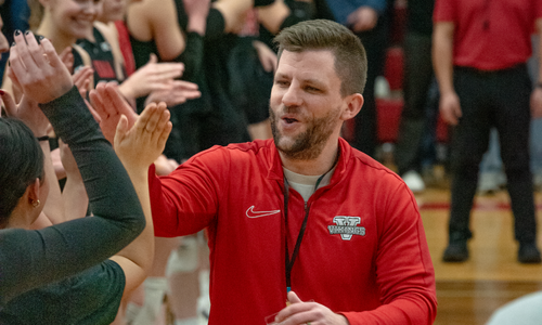 Steve Enright giving high fives to players during a game.