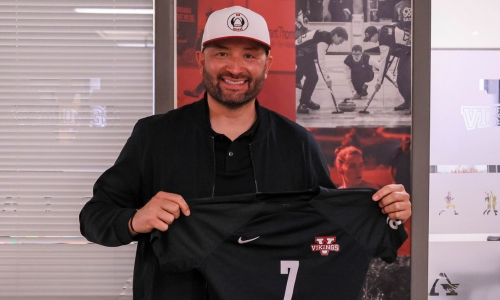 Pablo Valenzuela holding up a Vikings soccer jersey and smiling.