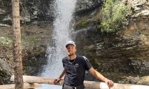 Justin Krewenchuk standing in front of a waterfall.