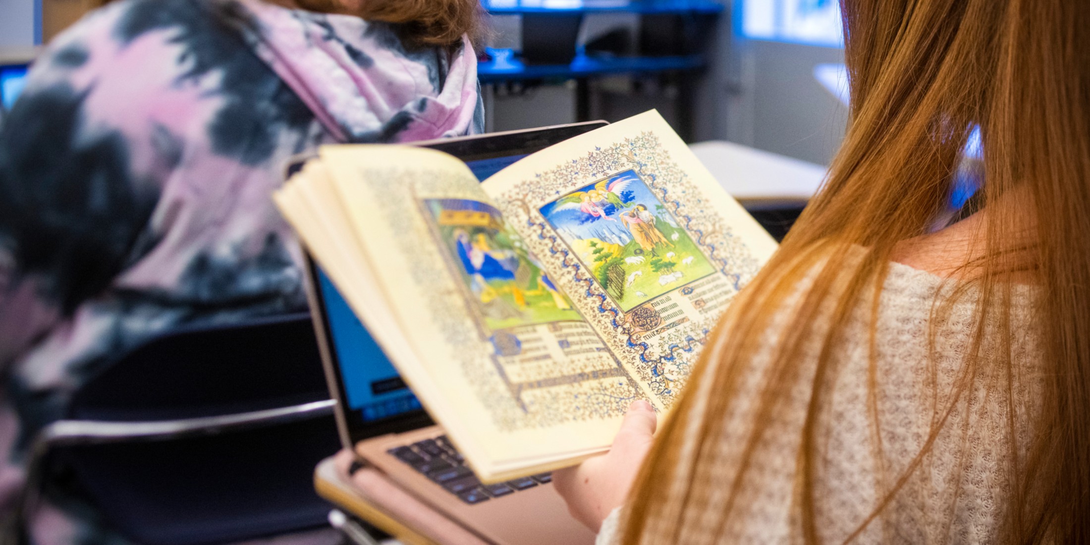 Woman reading book with beautiful artwork