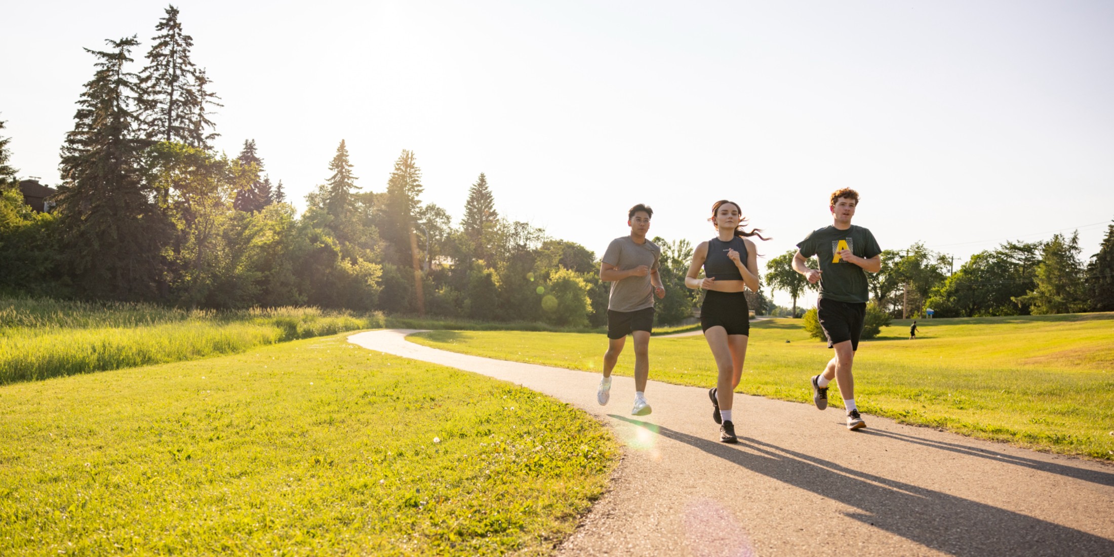 Three people running on a path outside