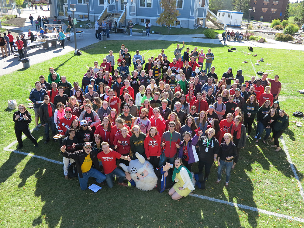 A photo of a large group of people posing for the camera in the middle of the quad