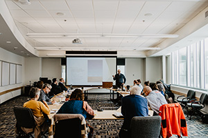 A photo of a speaker talking to a room of people