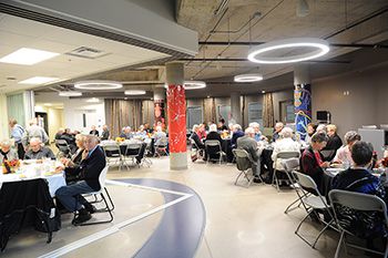 People at tables spread throughout Wahkohtowin Lodge