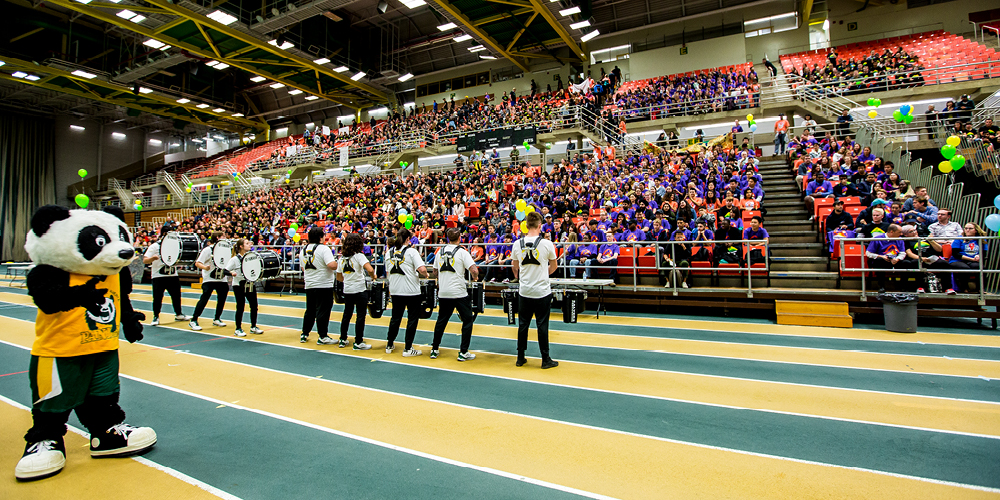GUBA and a drumline performing for a crowd on the Butterdome track