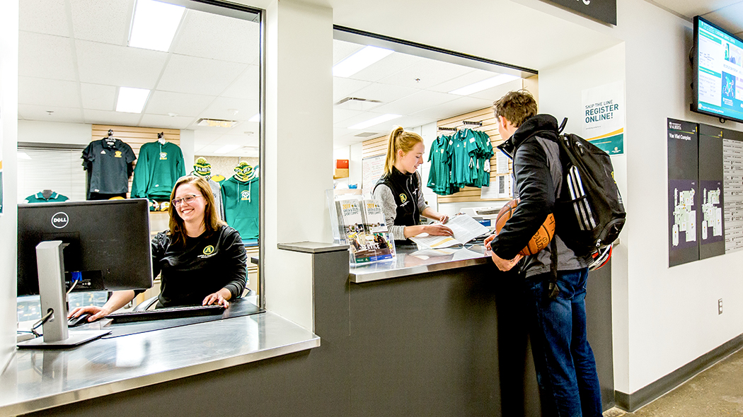 Student visits the front desk at Van Vliet Centre.