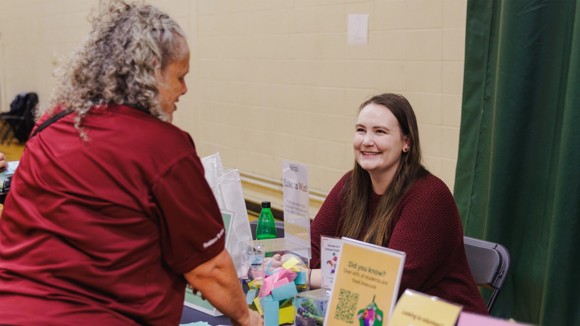 Someone sharing information about Heroes for Health at a tabling event
