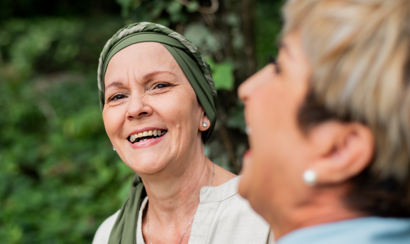 woman with a scarf covering her head laughing with another woman