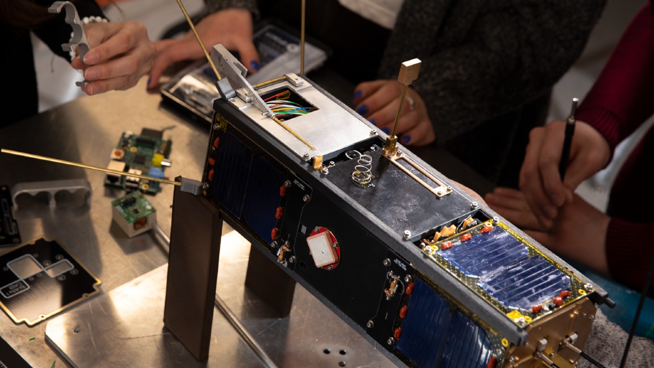 mechanical device with people standing around working on it. 