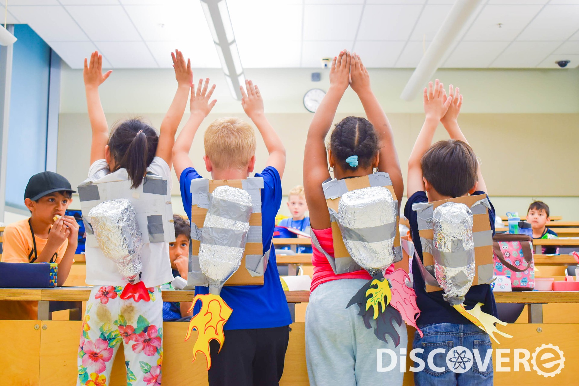 Three kids with pretend rocket packs on in the Fred Otto Discovere Program