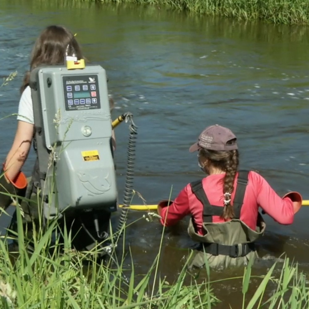 Two people in the water with testing equipment