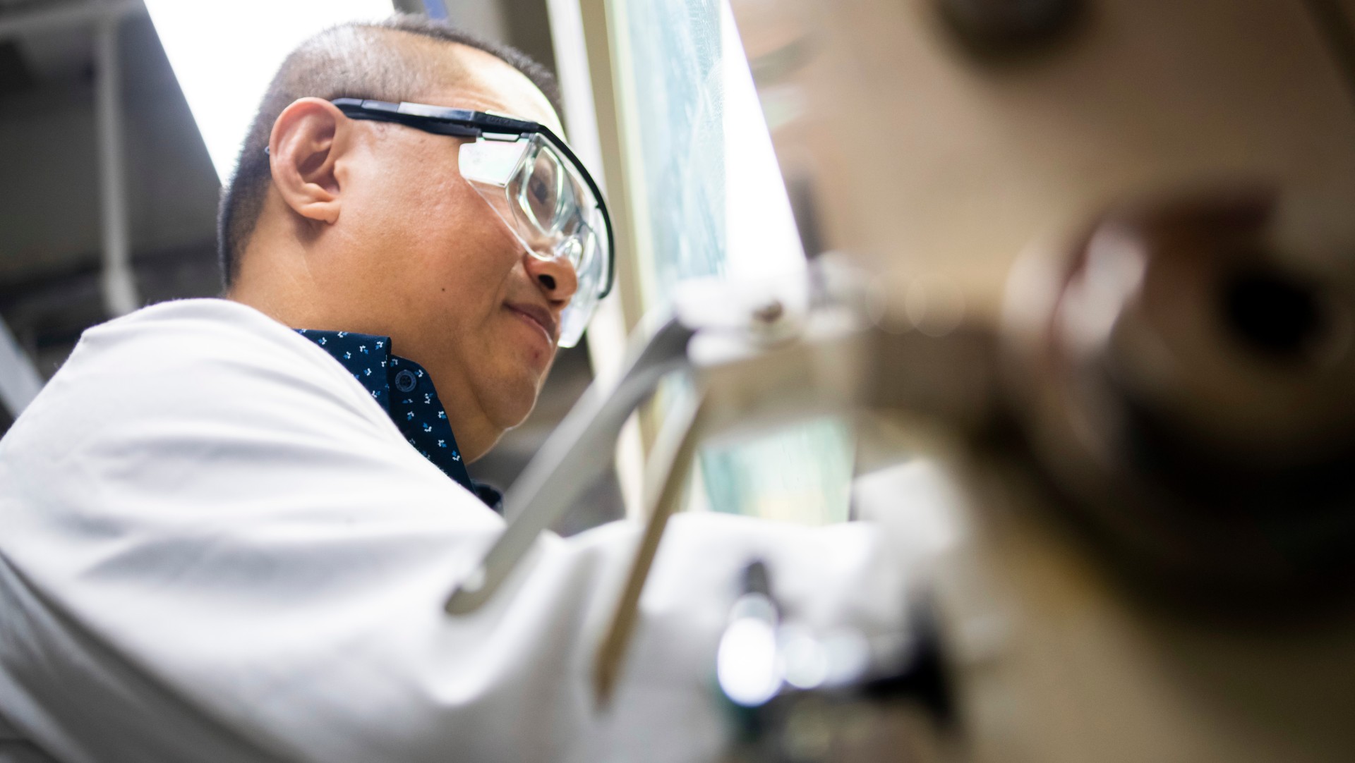Man in PPE working in a lab.