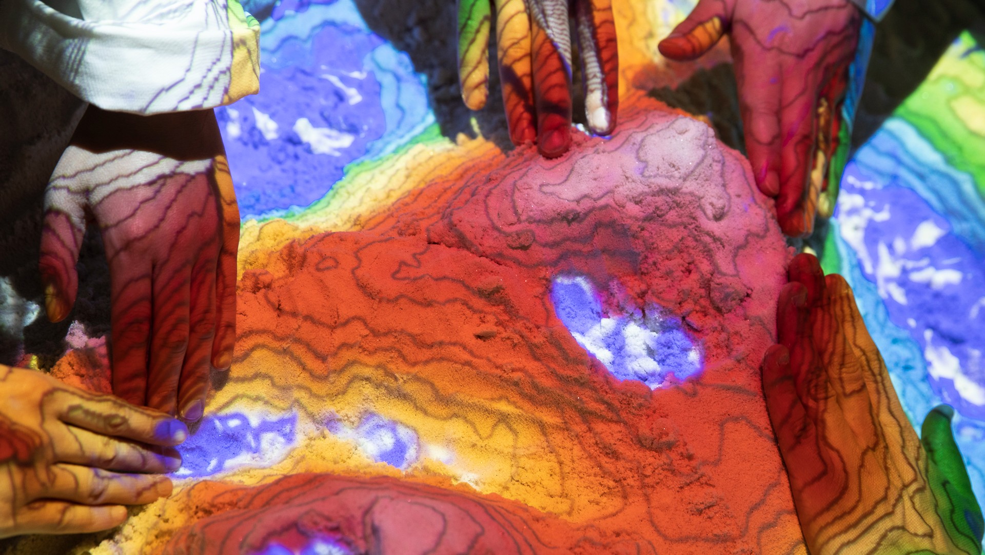 Hands touching a colourful map