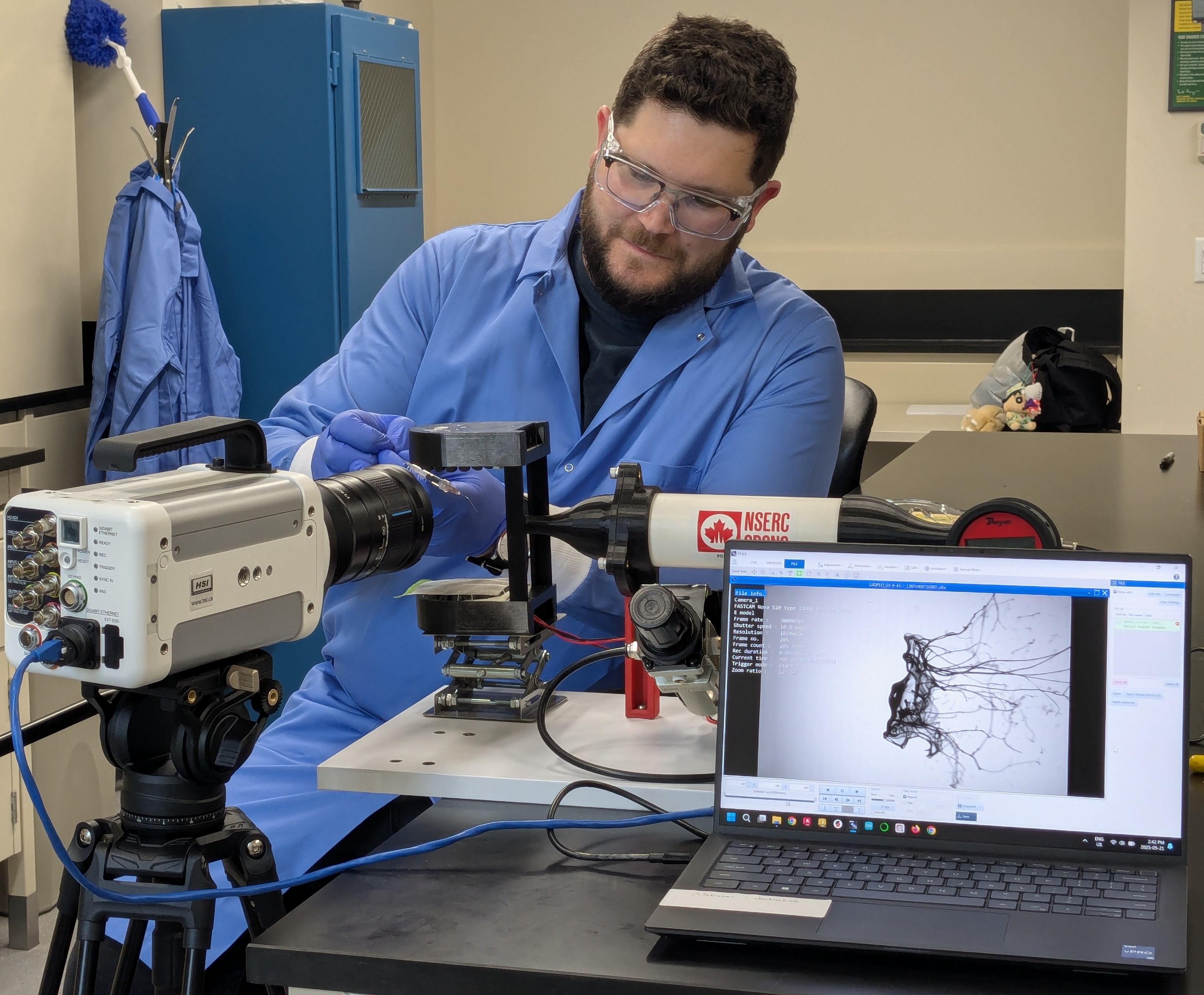 Researcher conducting an experiment in a lab wearing protective clothing.