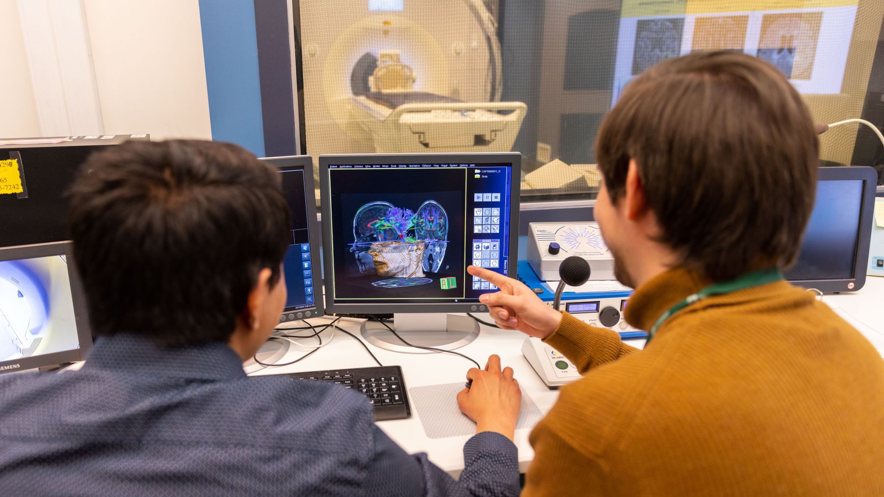 Two researchers staring at a 3d model of a man's head on a screen