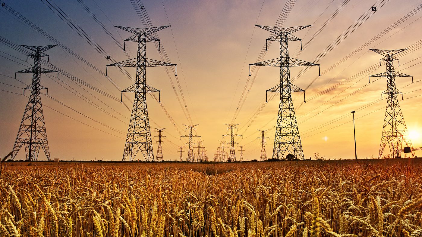 Powerlines in a field at sunset