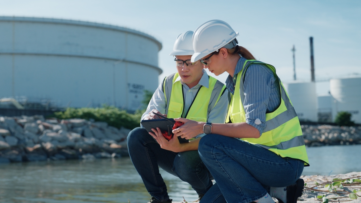A man and woman measuring levels in the water using a device