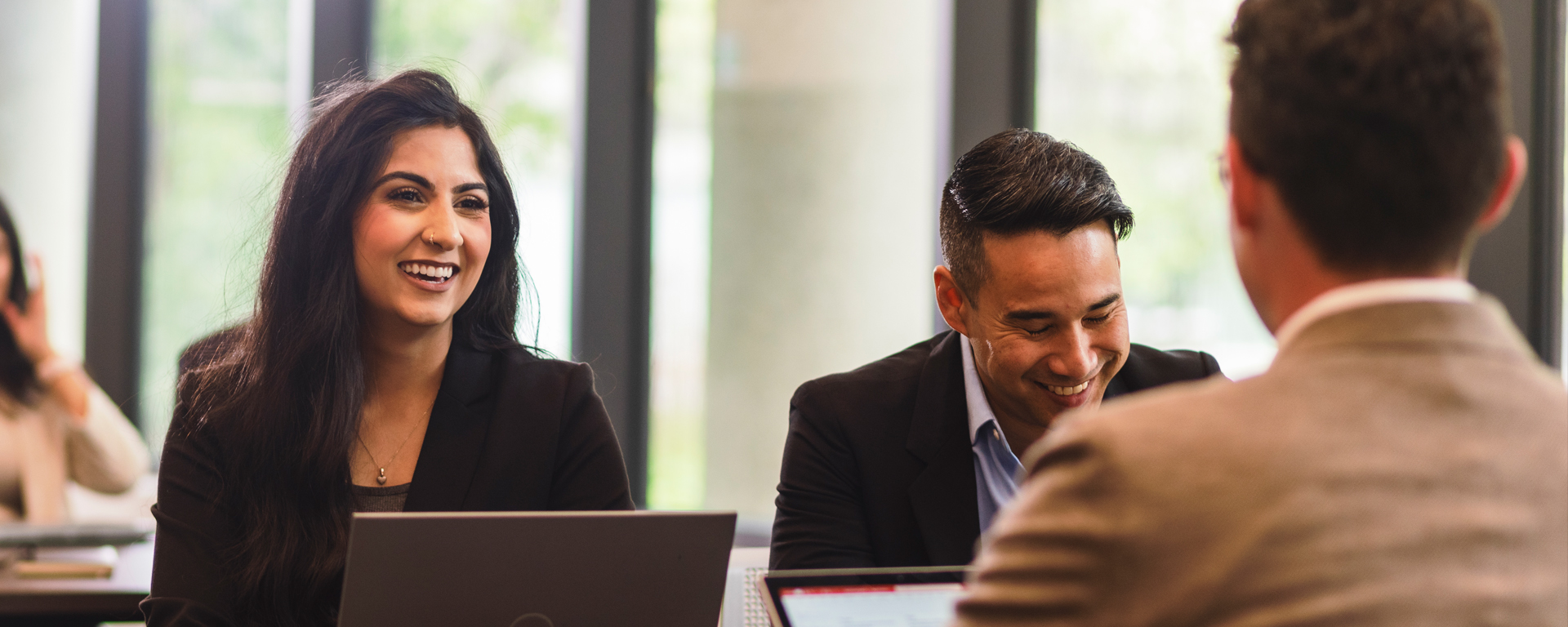 Postsecondary students sitting at a table having discussions and problem solving