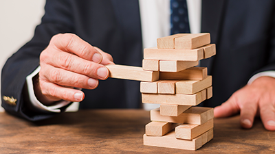 person playing wooden block game Jenga