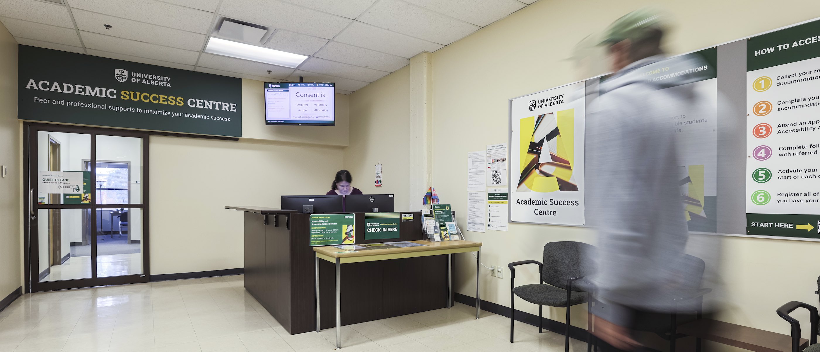 Academic Success Centre lobby, with the receptionist behind the desk and a man walking towards her