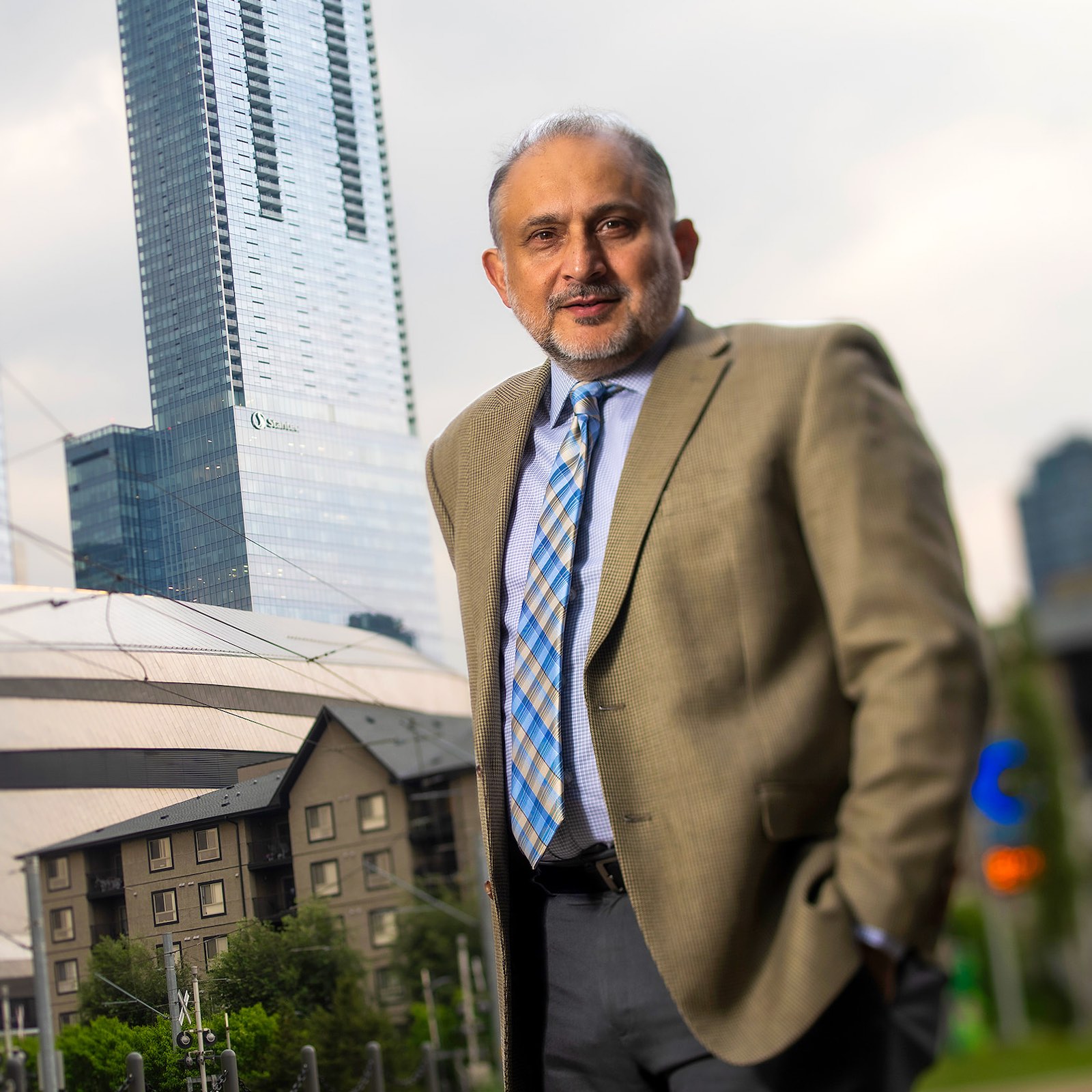 Murtaza Haider in front of downtown Edmonton buildings and LRT cables