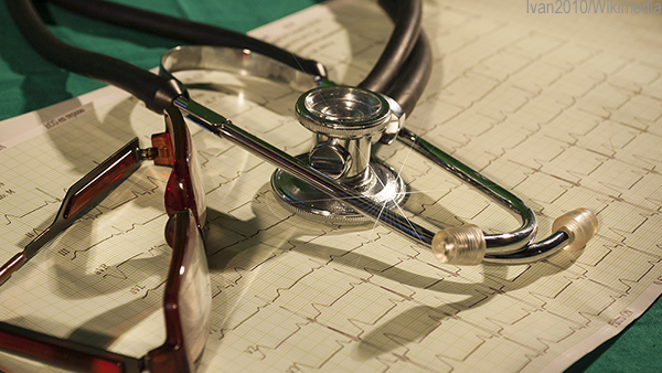 Stethoscope and glasses sit on a cardiology print out. 