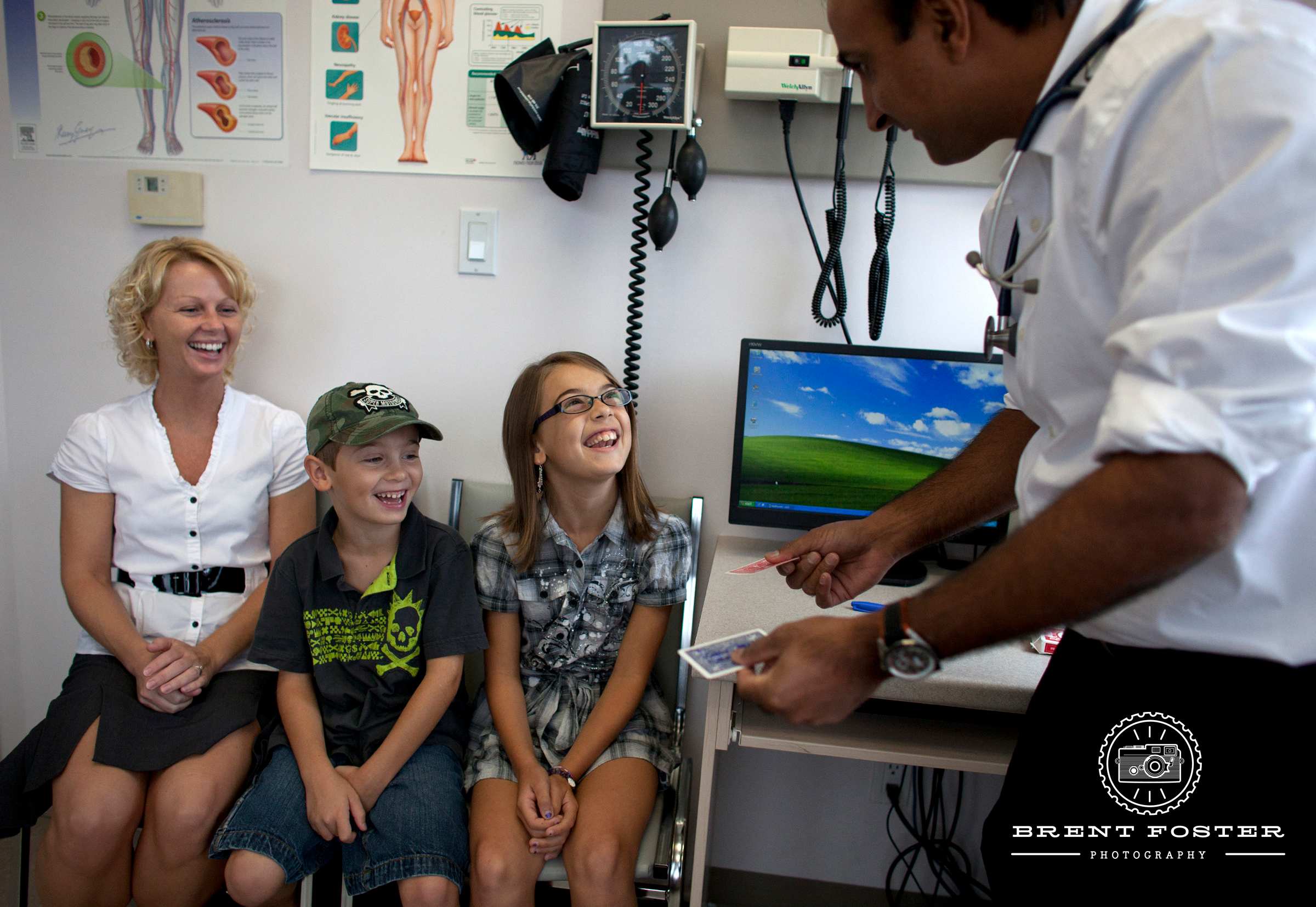 Lalit Chawla performing a card track for a family in a physician's examination room.