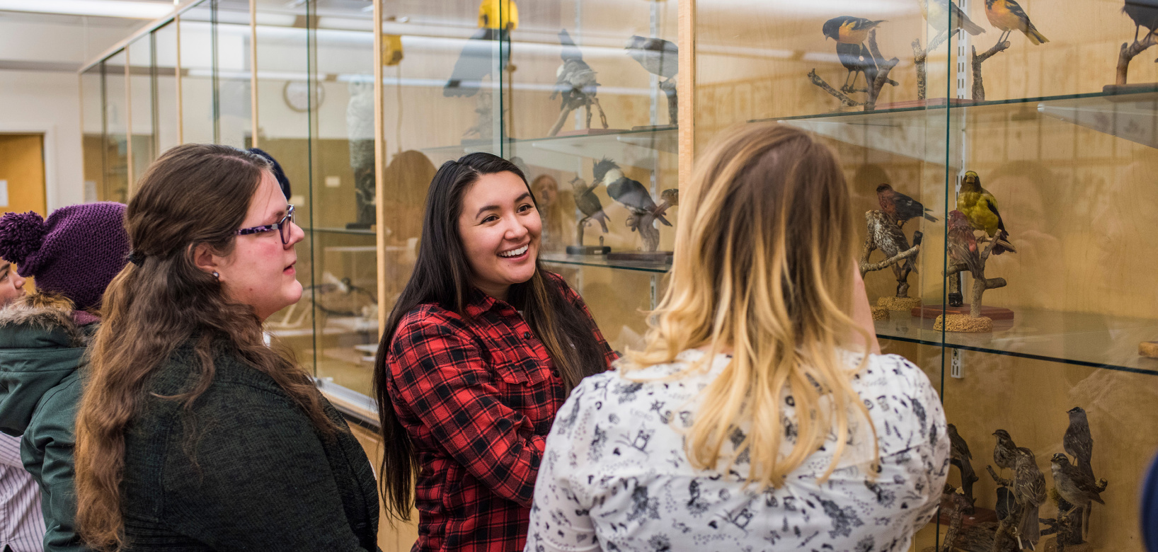 Woman leading a tour and standing in front of the collection