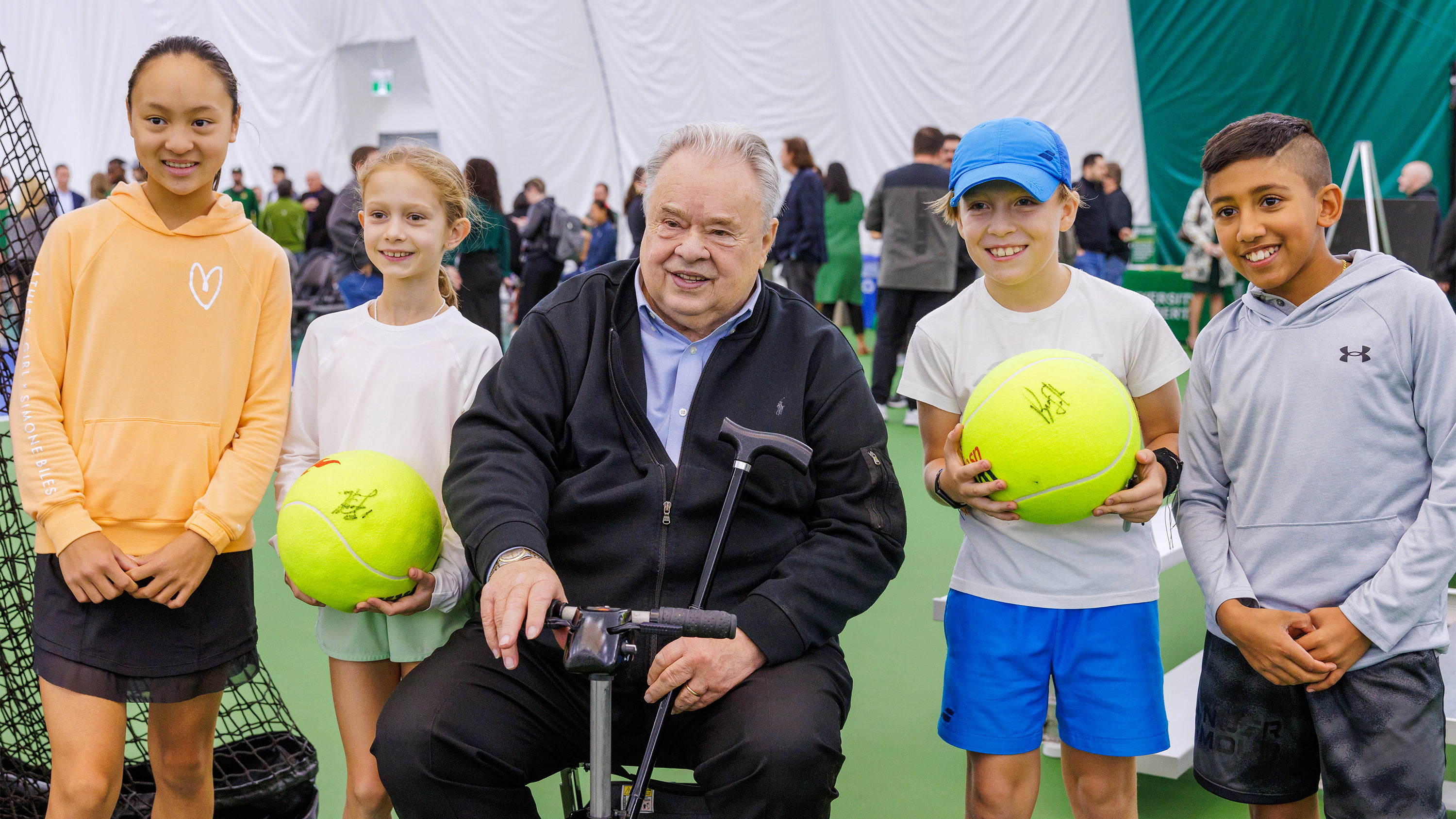 Bruce Saville with young tennis fans at the opening of the Saville Tennis Centre in 2023