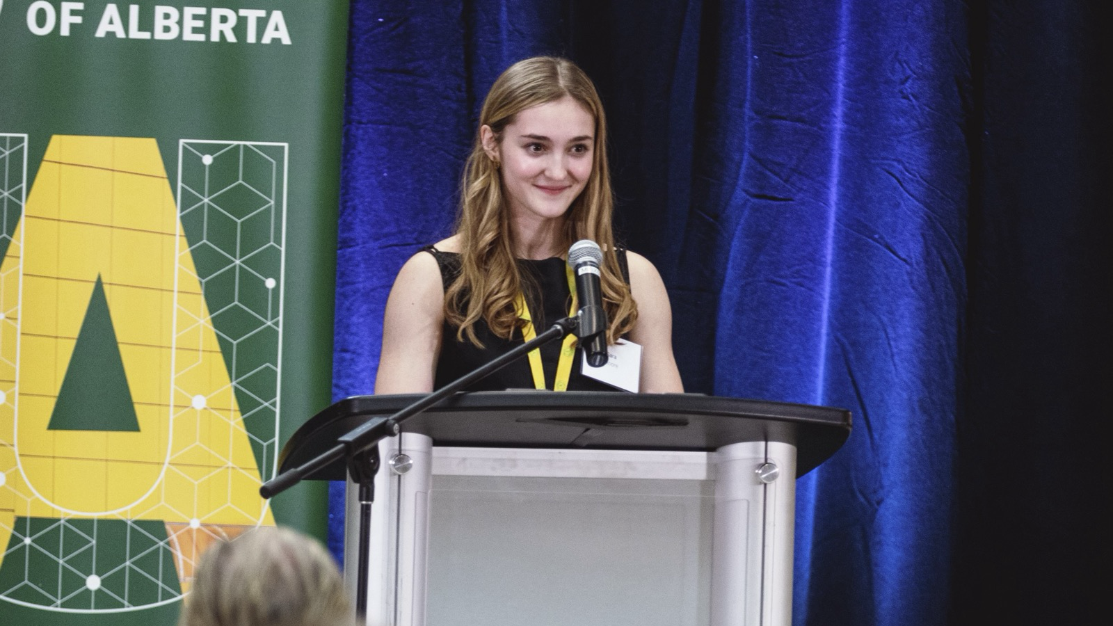 Student standing at a podium with some audience visible in front.