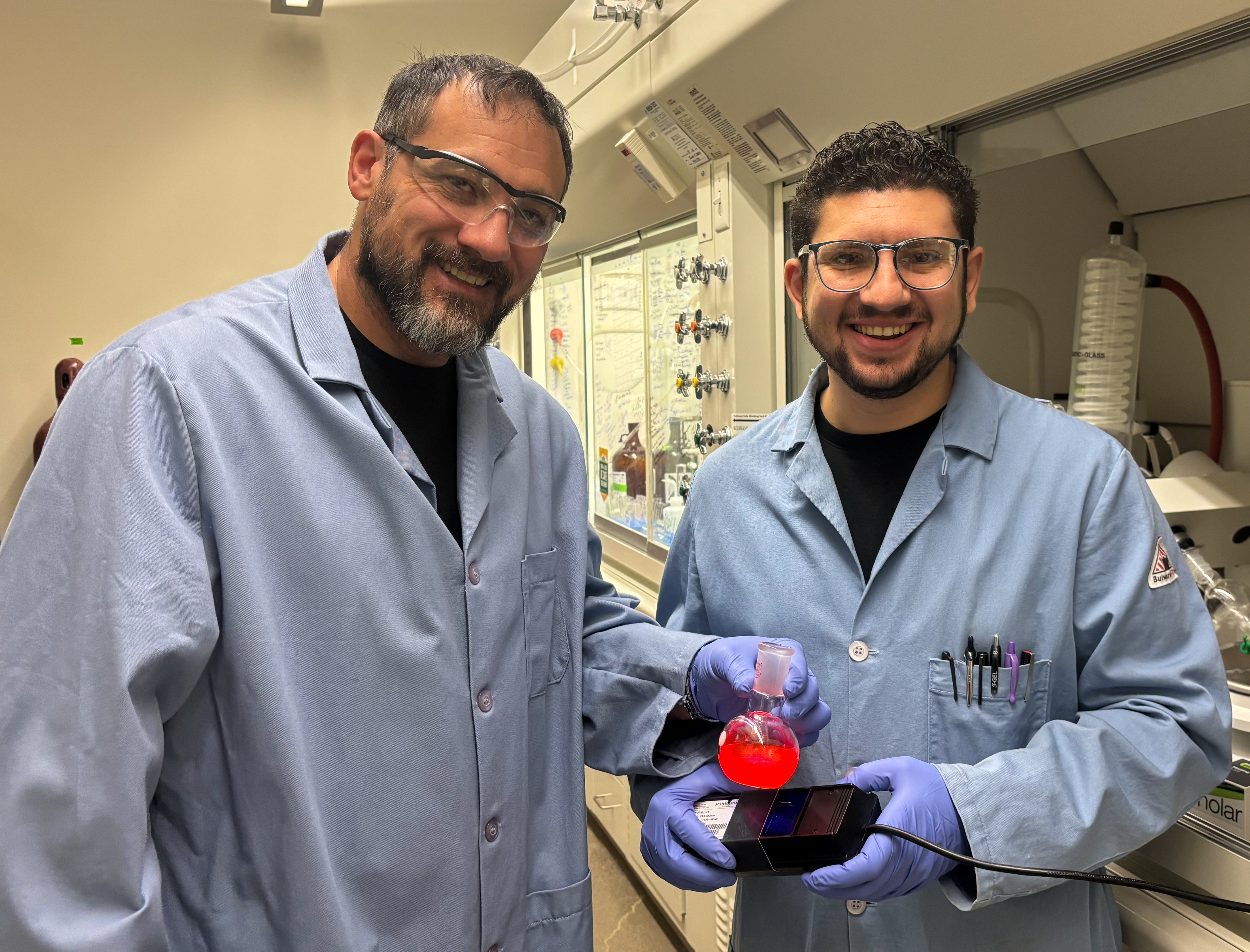 Wesley Chalifoux and Nicolai Gois with one of the ‘highly red' fluorescent materials used in their lab. Photo supplied.